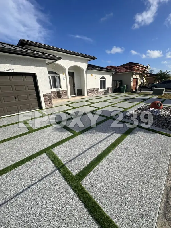 Driveway with grass strips in front of a house, coated in Gravel flake epoxy