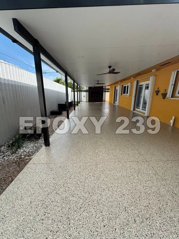 Long covered lanai beside a yellow house, coated in Shoreline flake epoxy