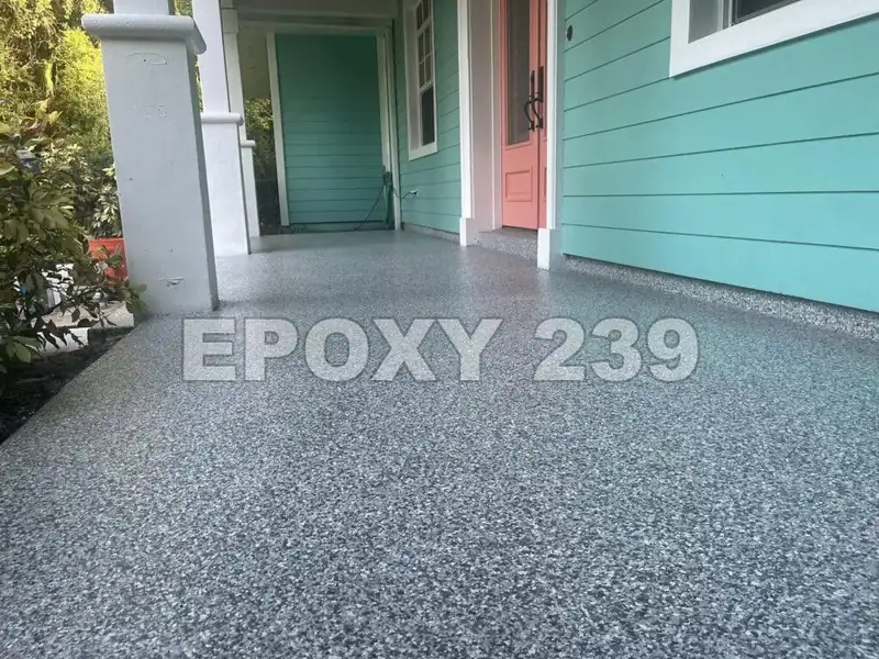 Front porch of a teal house coated in Gravel flake epoxy